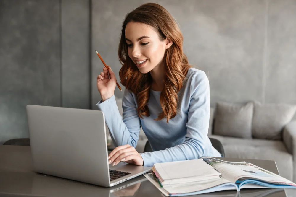 Mulher estudando com um computador e caderno